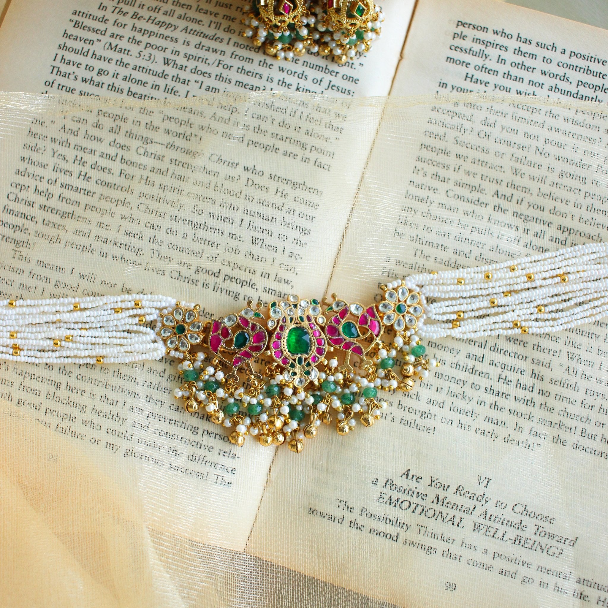 Close-up of the jadau kundan pendant with ruby and emerald inlay work