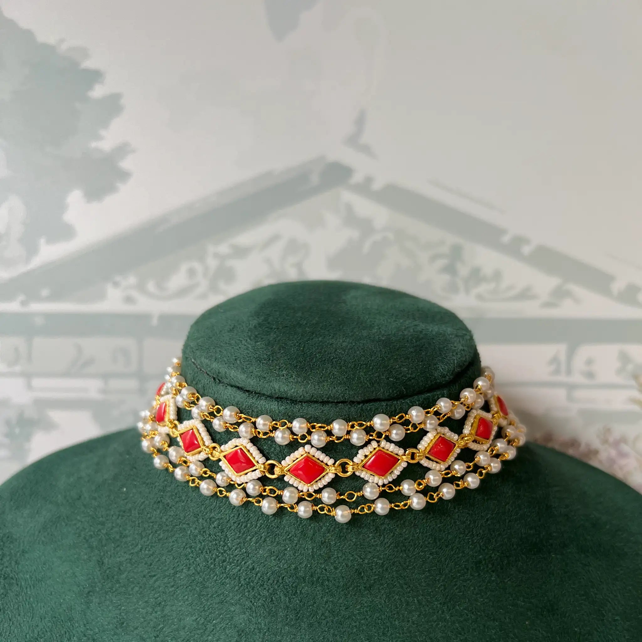Close-up of multi-strand choker with red stone and pearl beading