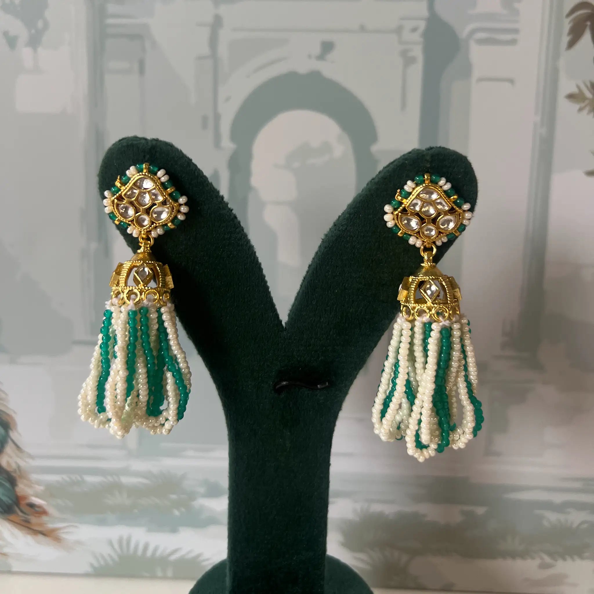 Green and white seed bead tassel jhumka earrings with white kundan polki stud and fluted gold bell