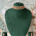 Gold-tone multi-strand choker with red kundan-style stones and pearl beading, with matching drop earrings
