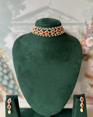 Gold-tone multi-strand choker with red kundan-style stones and pearl beading, with matching drop earrings