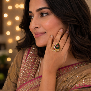 Gold parrot ring on a deep green ambi stone with flat-cut pink jadau work and a seed pearl fringe