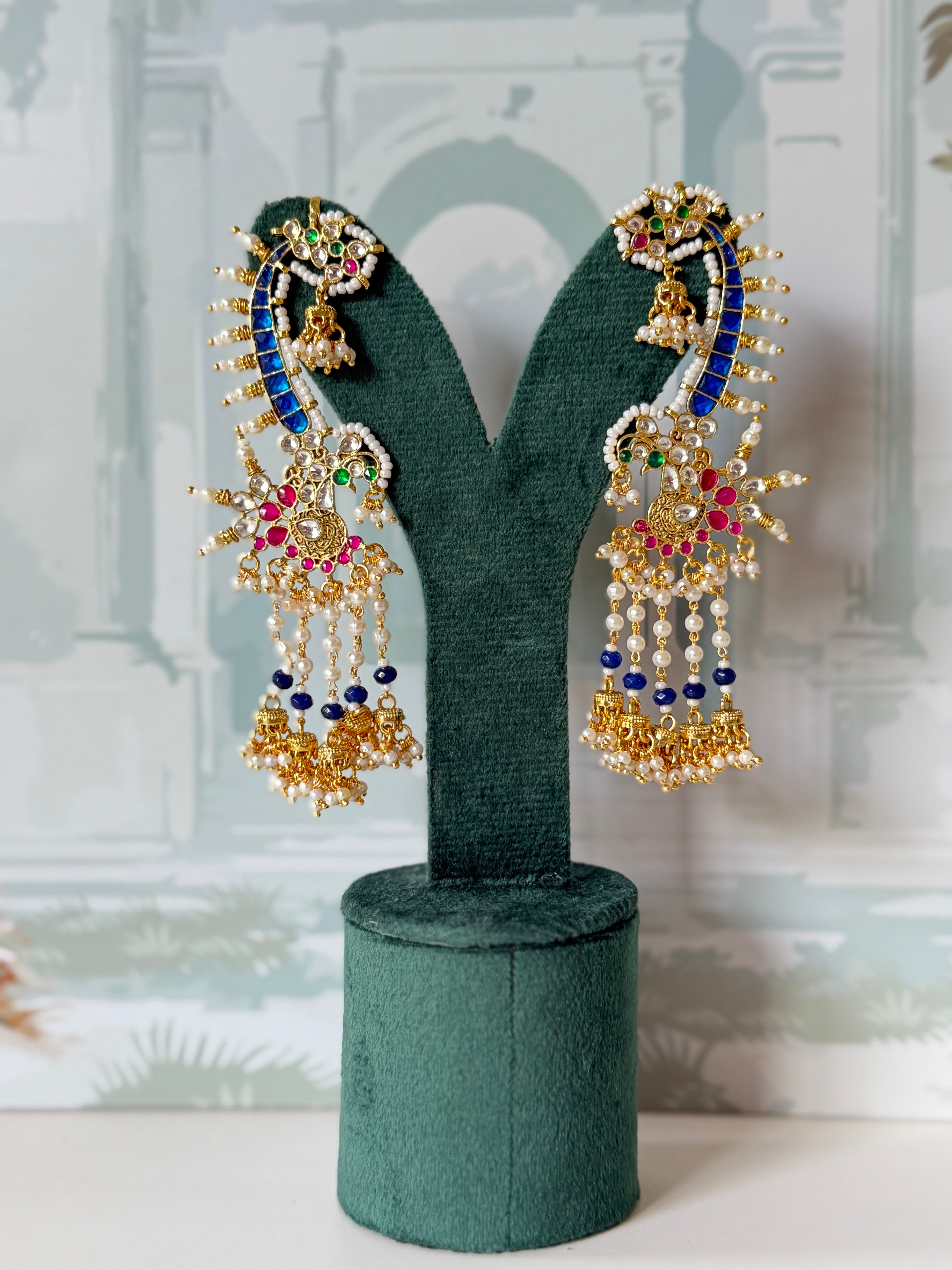 Royal blue kundan peacock ear cuff in gold with pearl-tipped rays and mini jhumka fringe