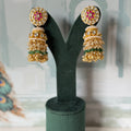 Pink and white kundan stud jhumkas in gold with seed pearl border, green beads and bell drops