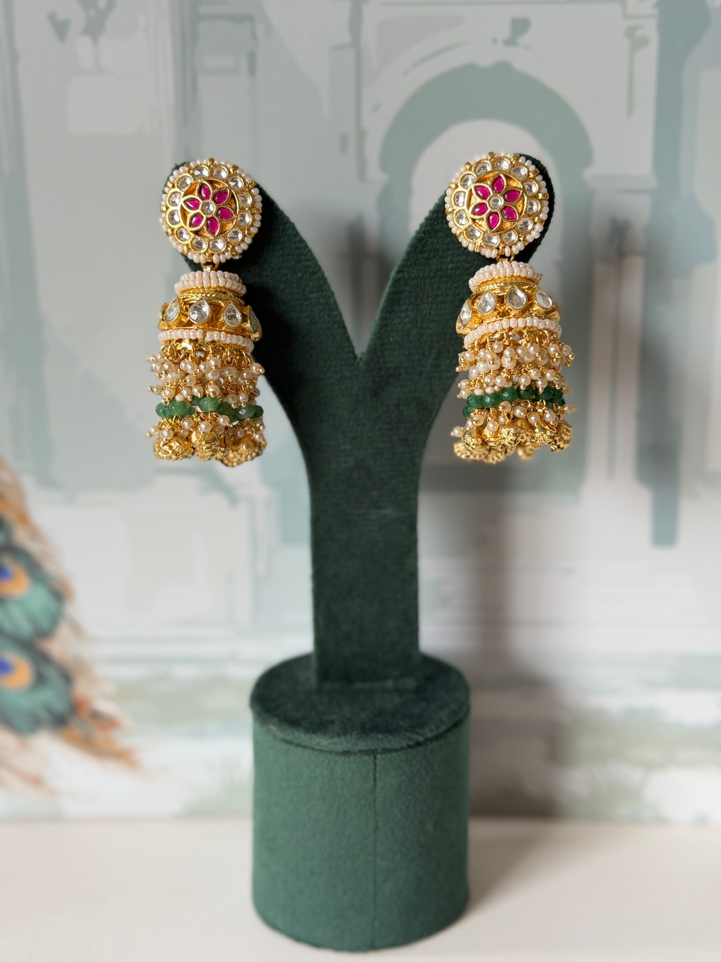 Pink and white kundan stud jhumkas in gold with seed pearl border, green beads and bell drops