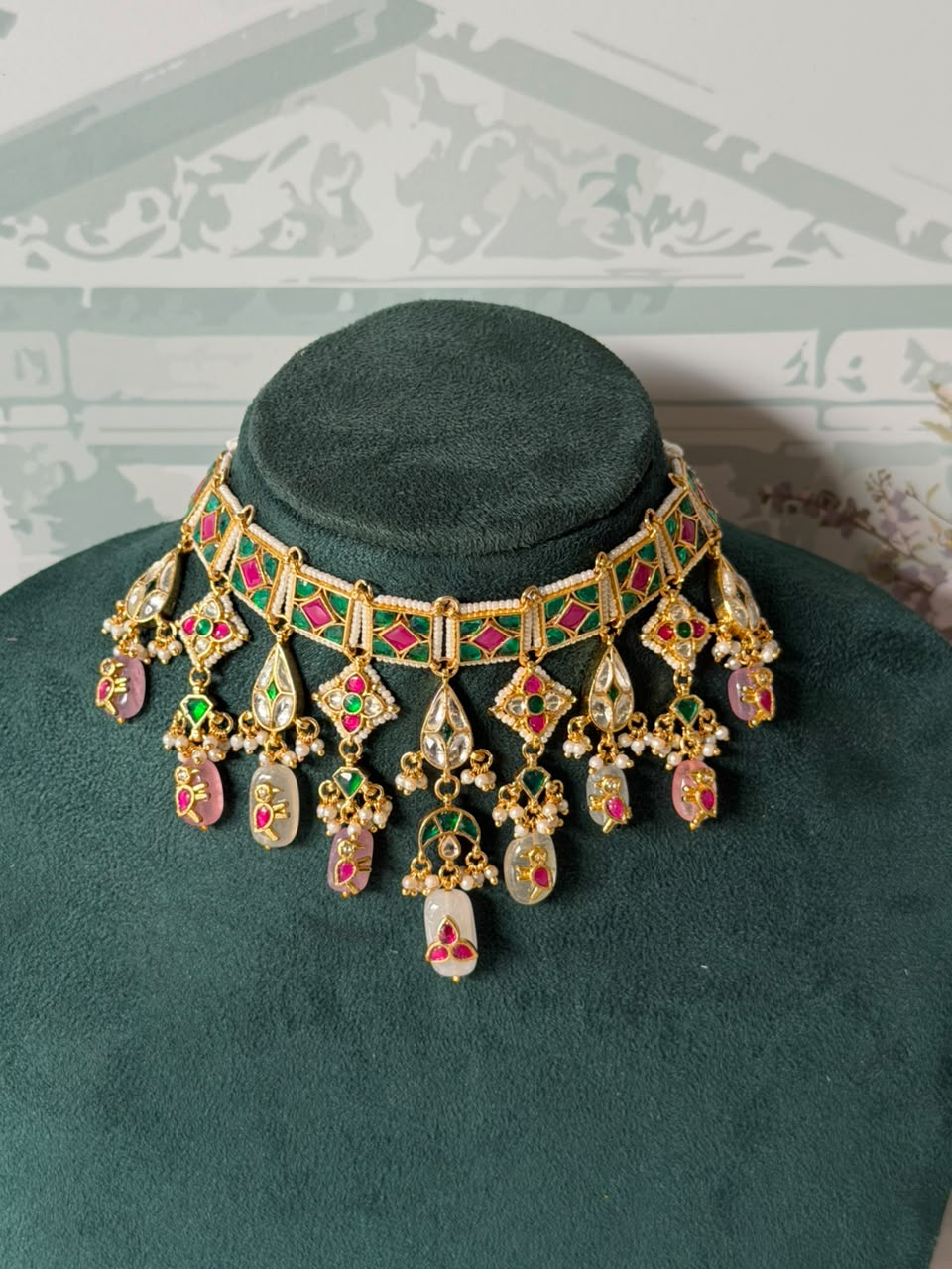 Green and pink jadau choker set with white kundan drops, seed pearls and carved bead fringe
